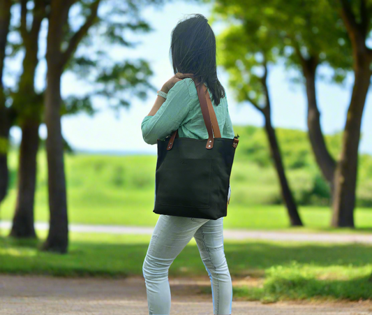 Handmade black and tan leather shopper bag crafted from full-grain leather. Features a front stitched pocket with embossed branding, a secure zip closure, and natural-tone double handles for easy carrying. A stylish and durable leather tote bag perfect for daily use, shopping, or work essentials.