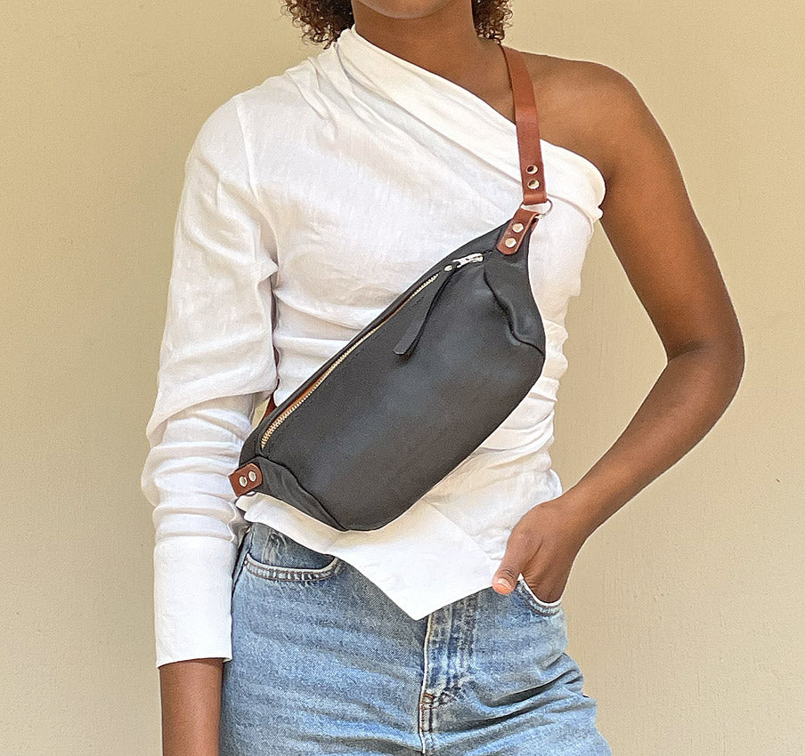 Petite model with the black and amber moon sling bag worn across her body. 